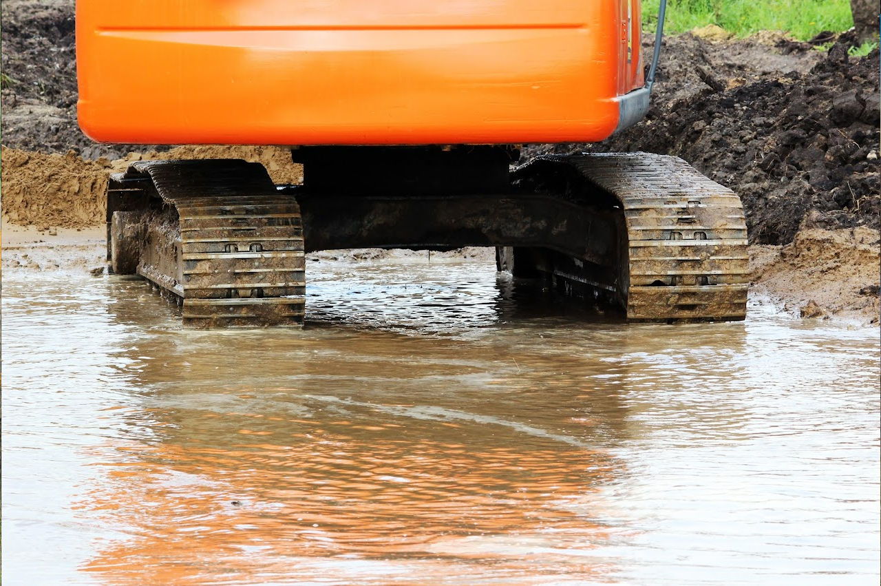 Image of an excavator in standing sewage because someone needed  Septic System Service Pekin, IL