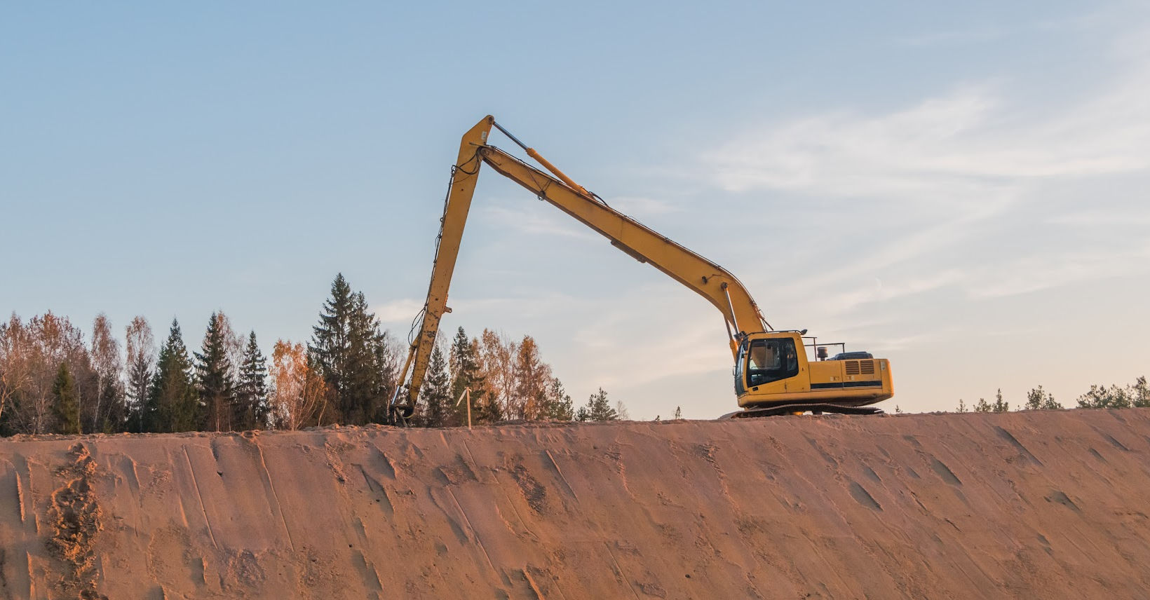 image of an excavator at the top of a hill