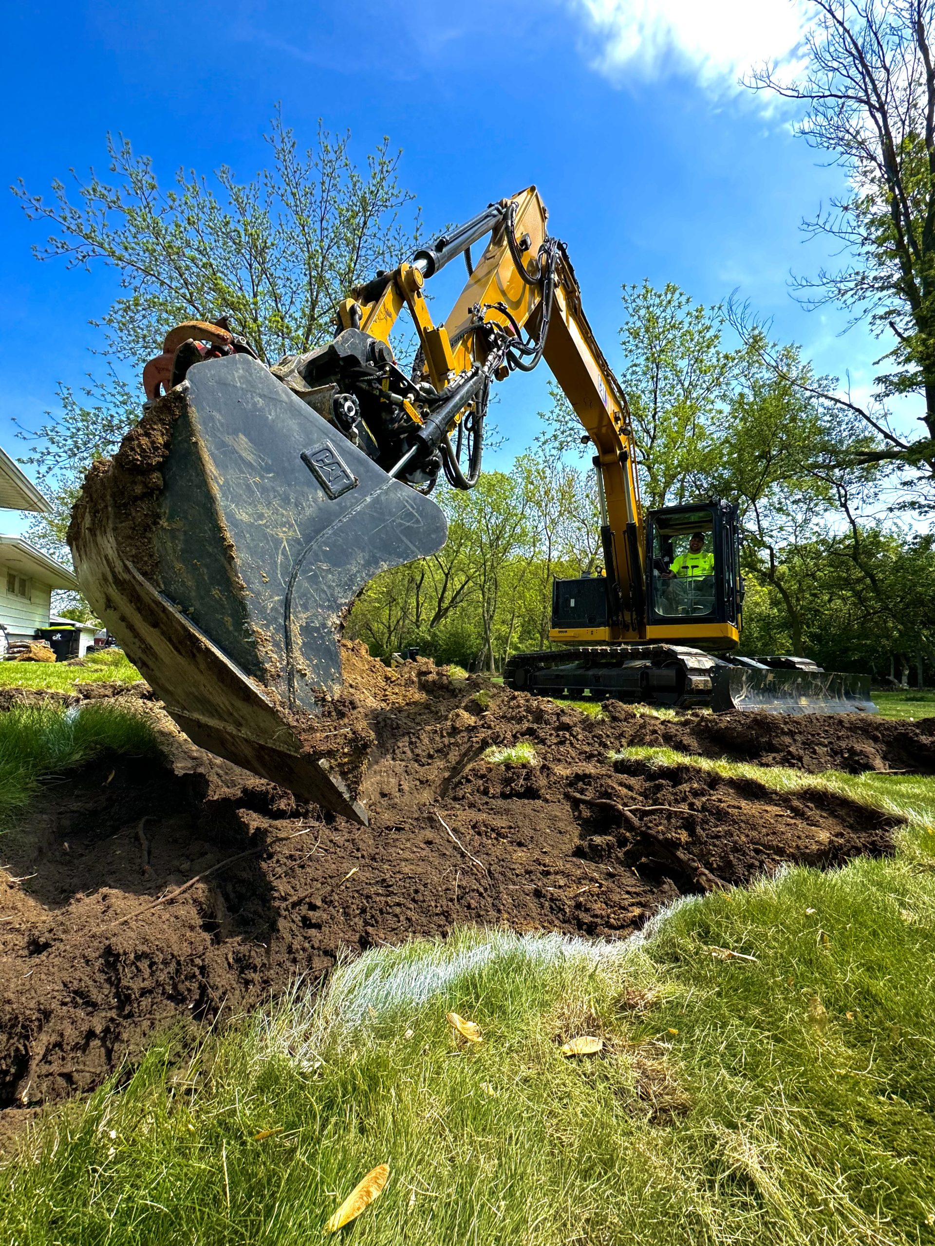 IMG_9774 Excavator digs a trench in a grassy yard