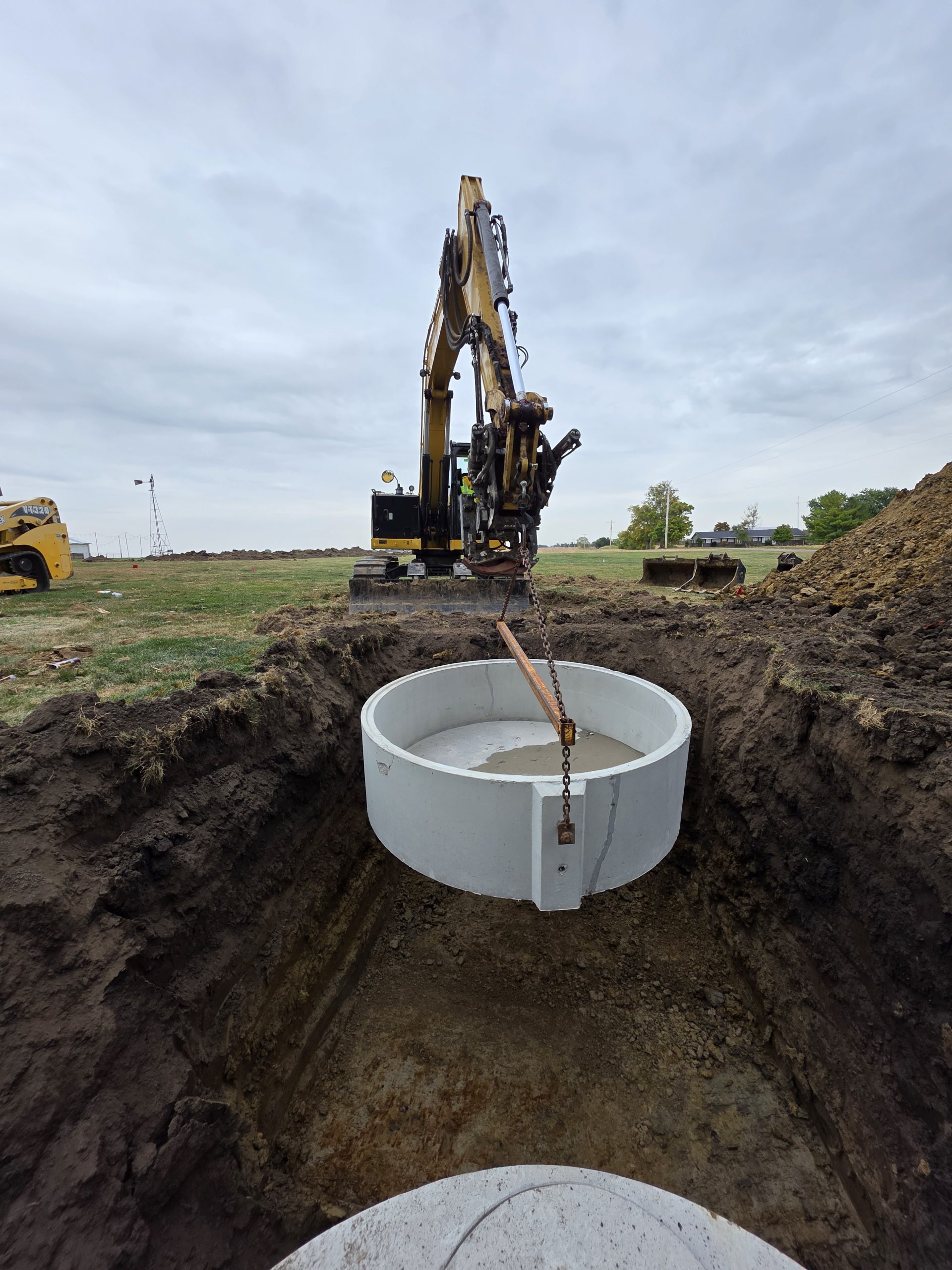 20251014_151013 Septic tank sits in a deep, grassy trench
